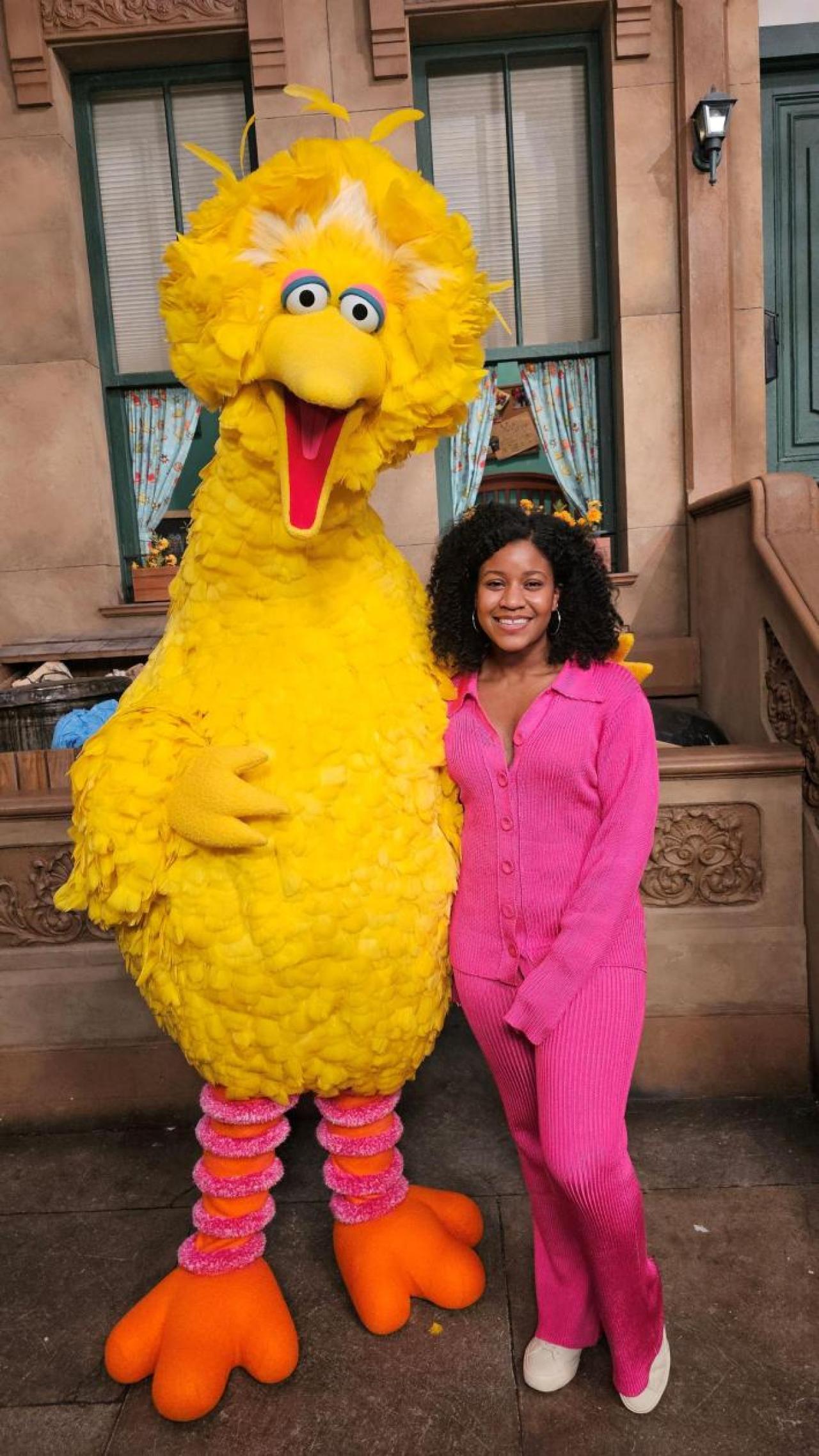 Woman in pink outfit on a production set