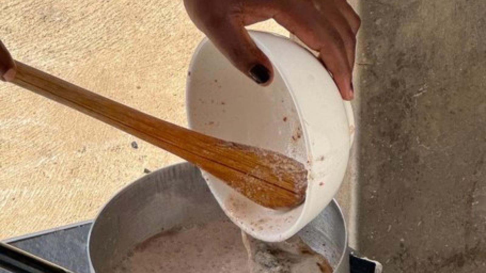 Global fellow cooking a pot of food on a makeshift stove in Zambia