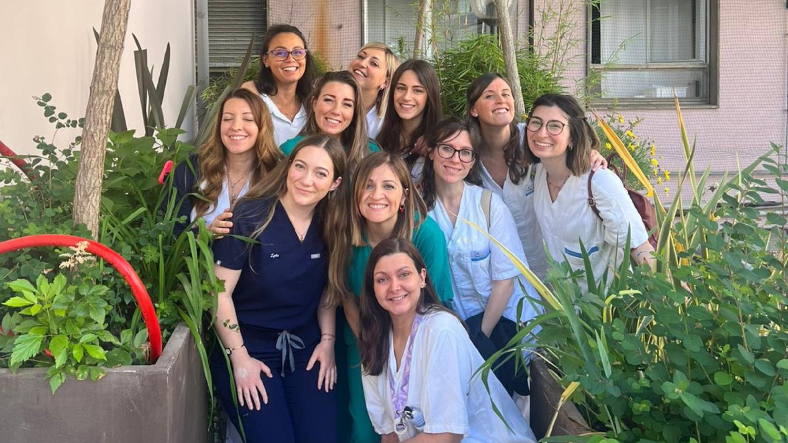 Group of nursing students in their scrubs standing outside a rural buildling