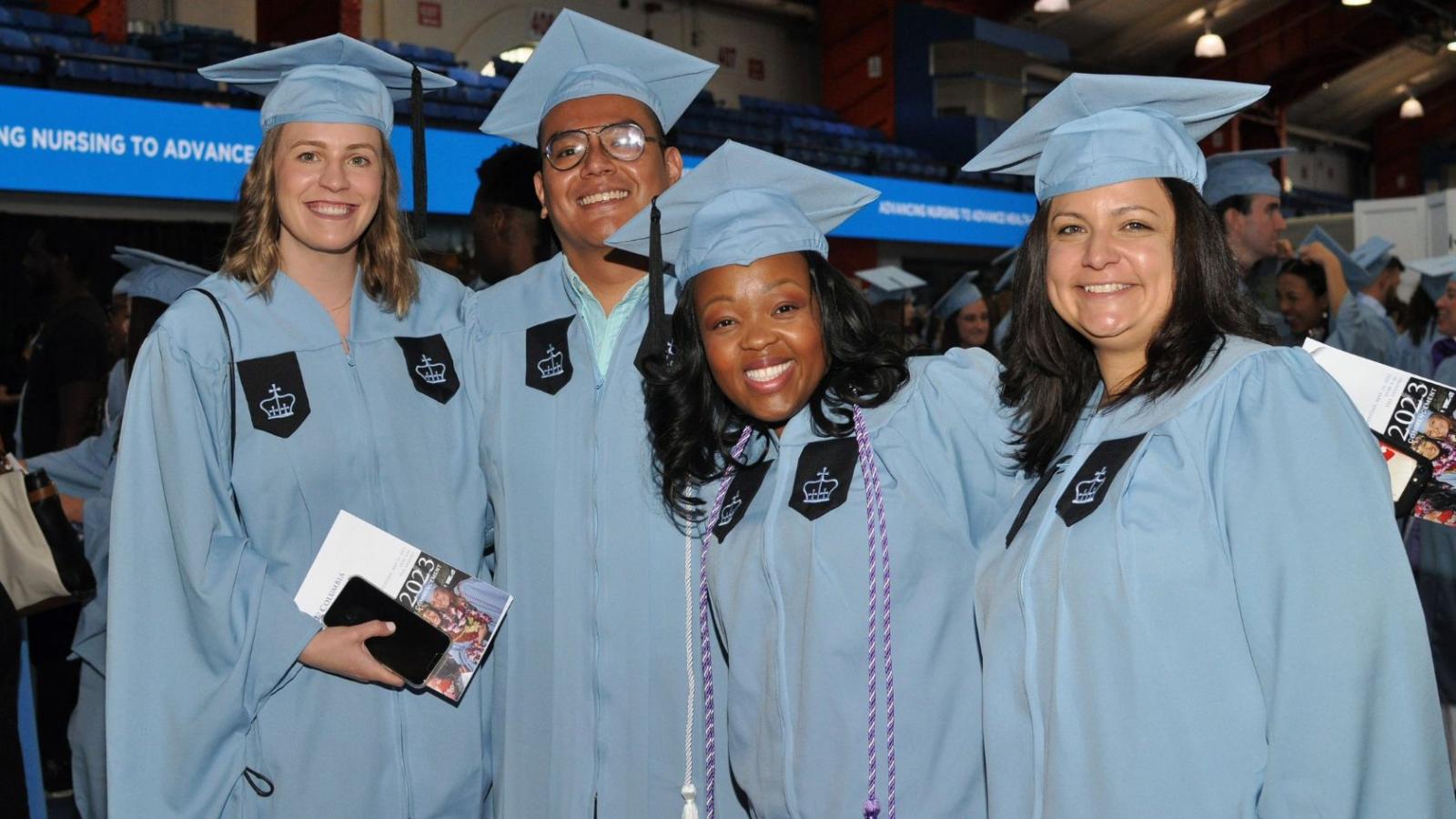 Students posing in cap and gown at graduation