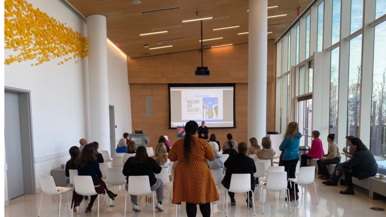 Seated gathering in front of projection screen