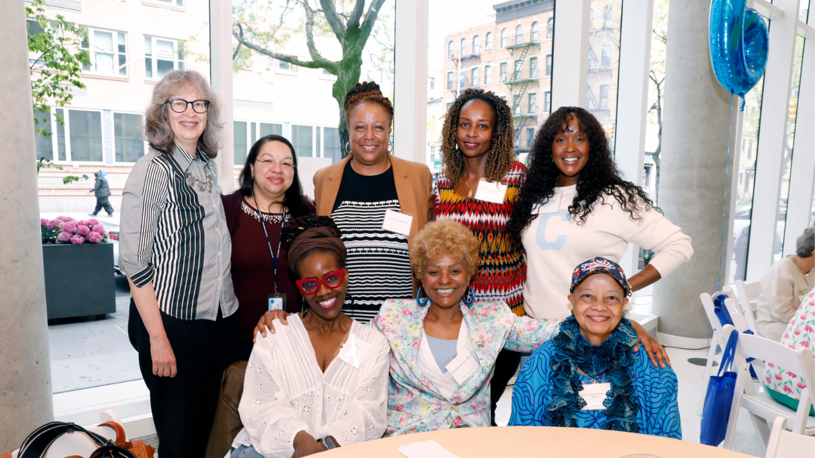 Columbia Nursing faculty and alumni posing for a photo in front of a table