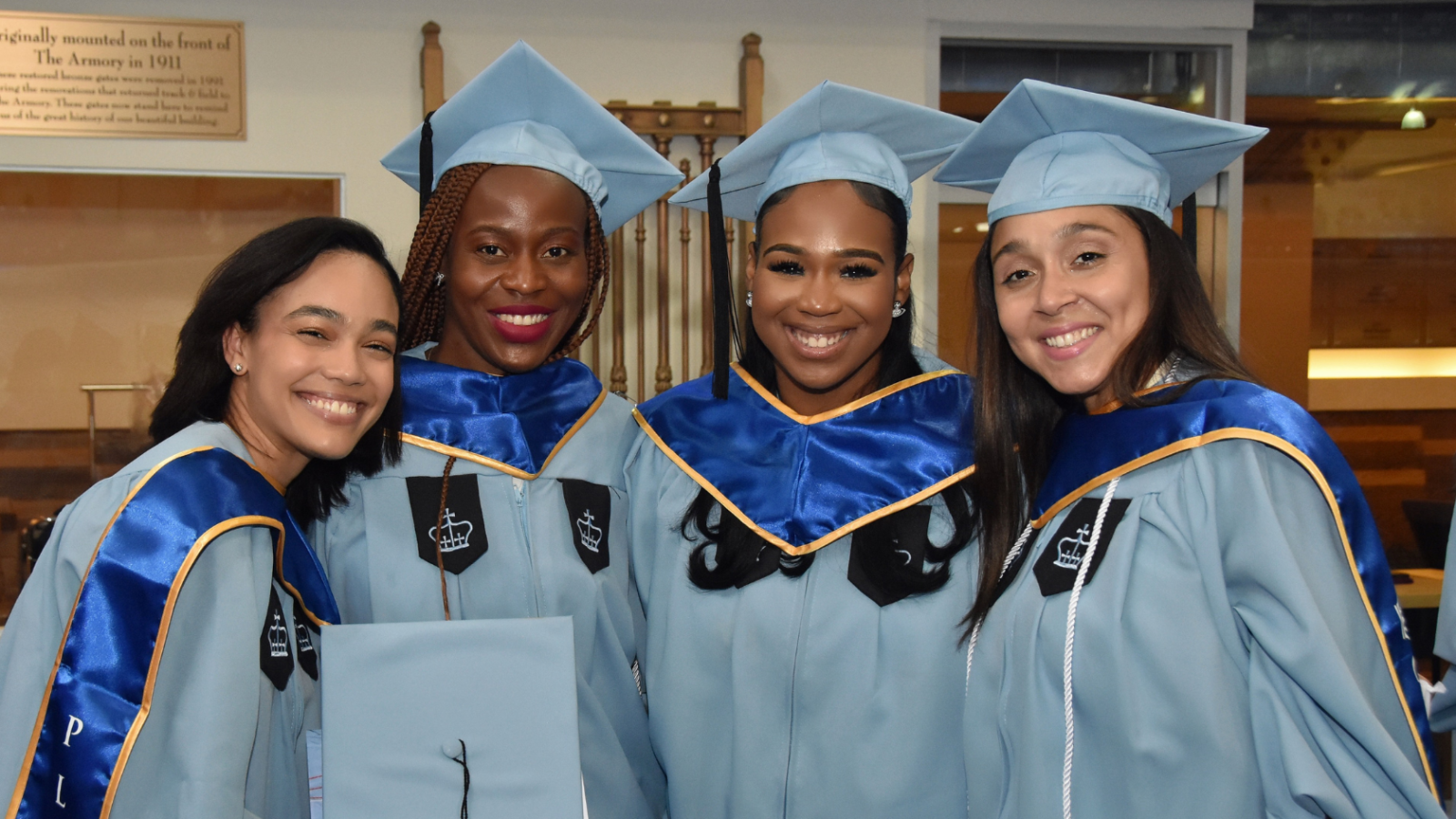 Four female graduate students lining up at graduation