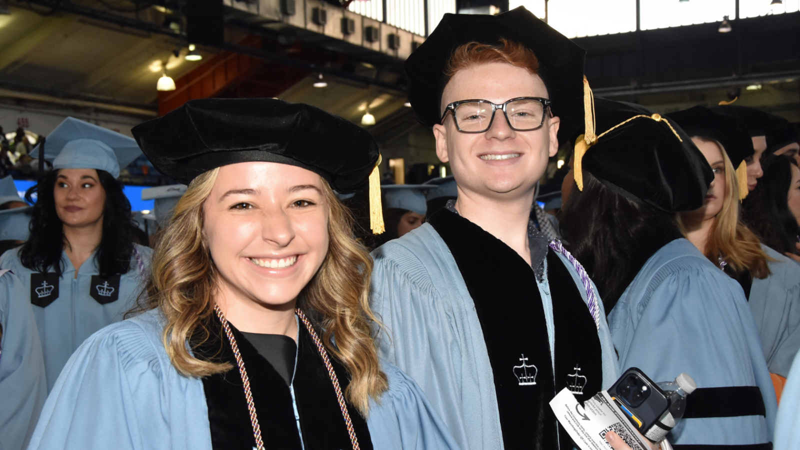 Two graduates posing after ceremony
