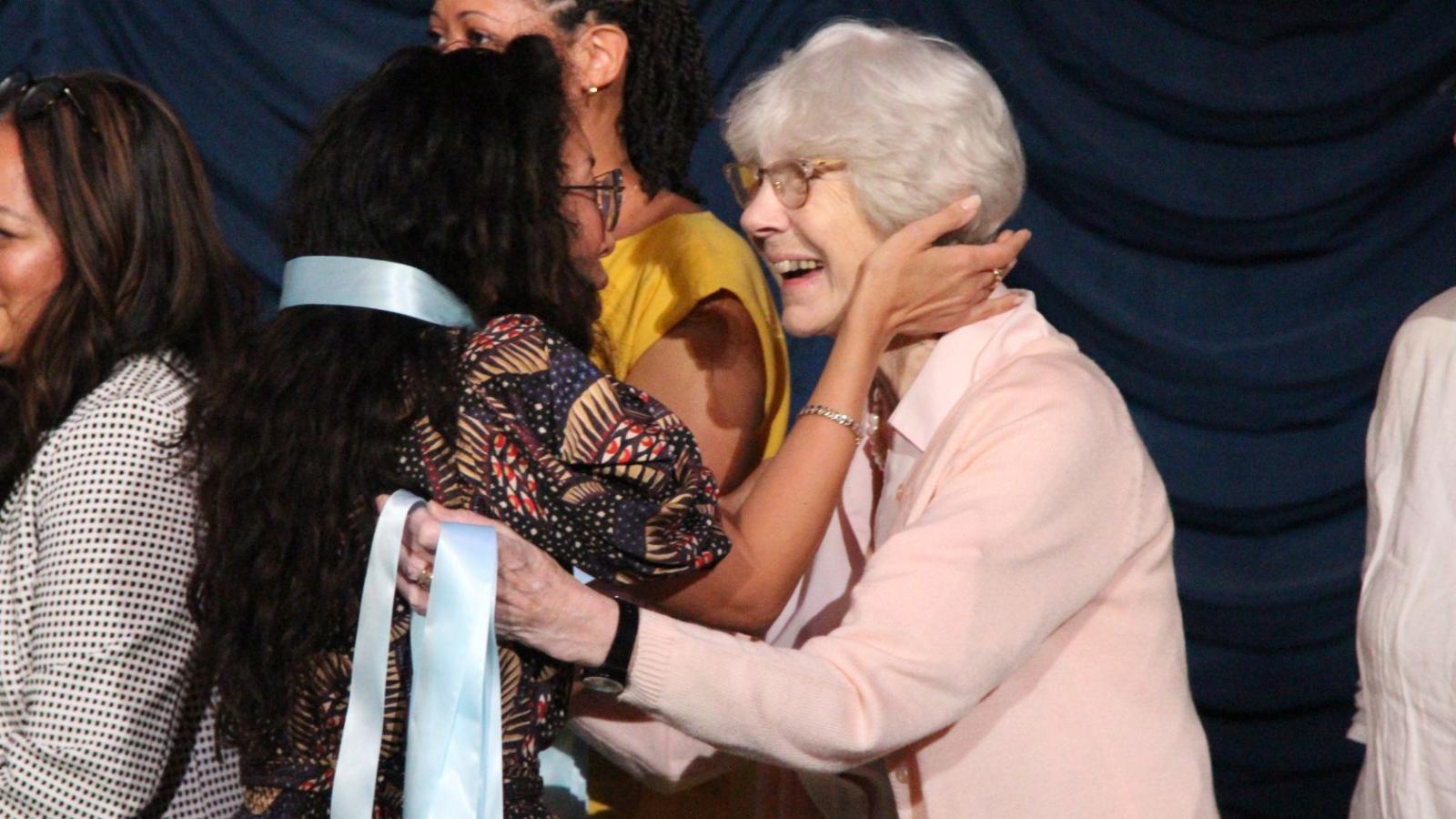 Nursing graduate and faculty embrace at pinning ceremony