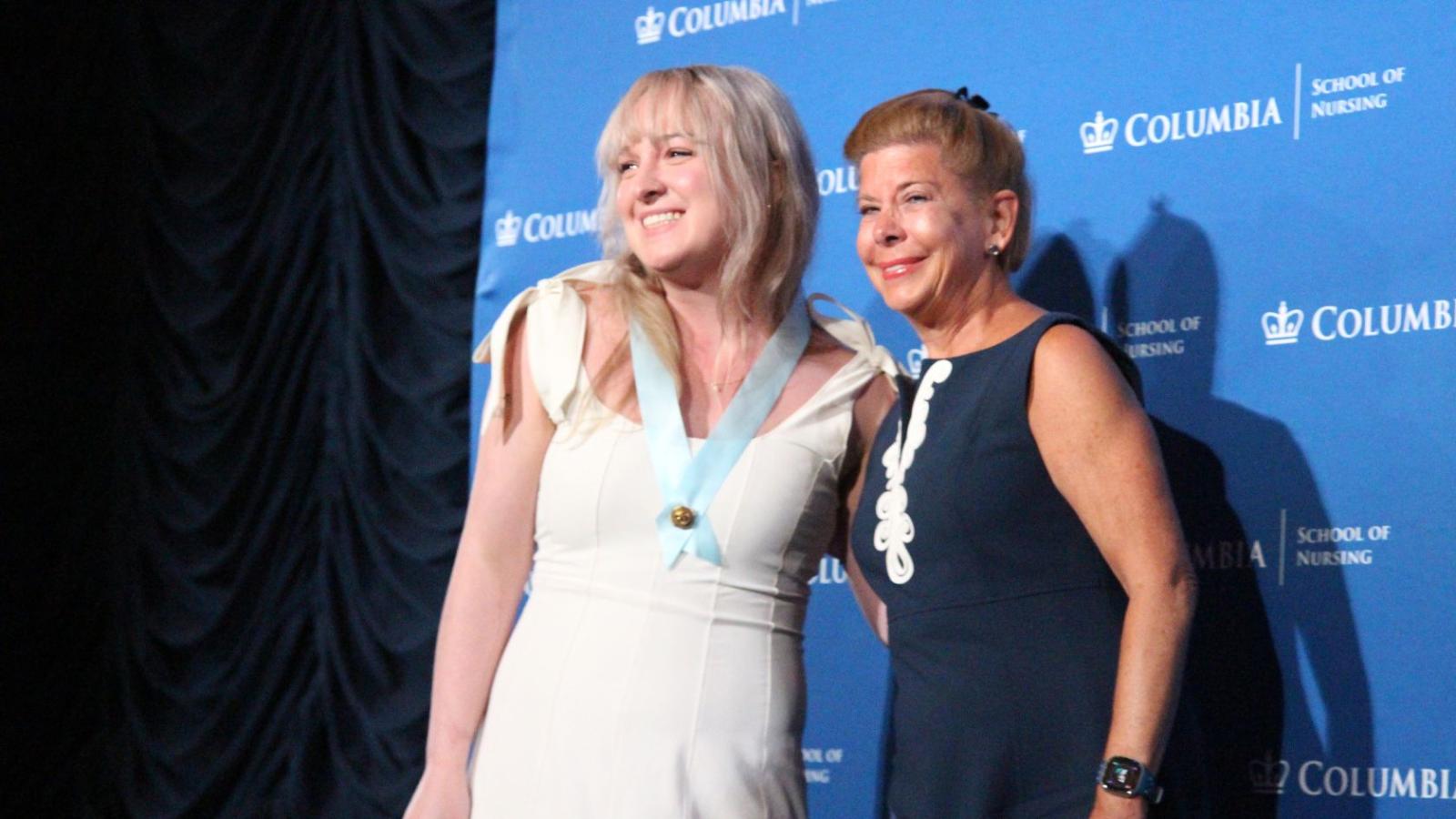 Nursing graduate posing with her mother on stage
