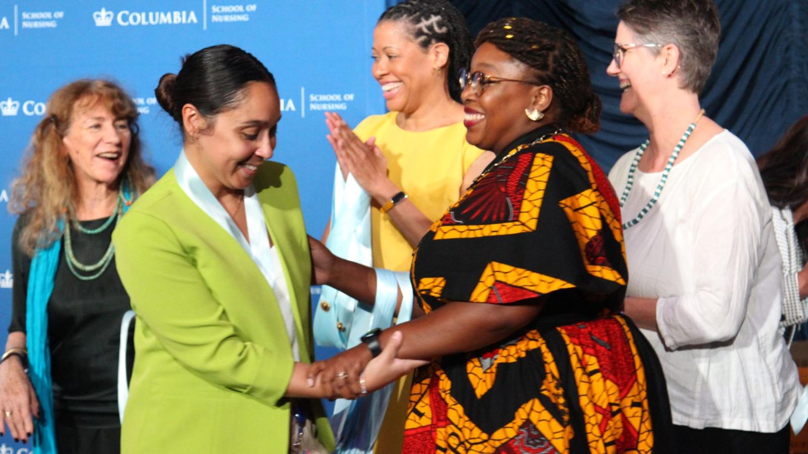Nursing graduate receiving gift from faculty during ceremony