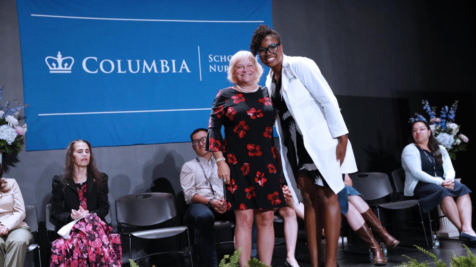 Student posing with faculty after receive their white coat at White Coat Ceremony 2024.