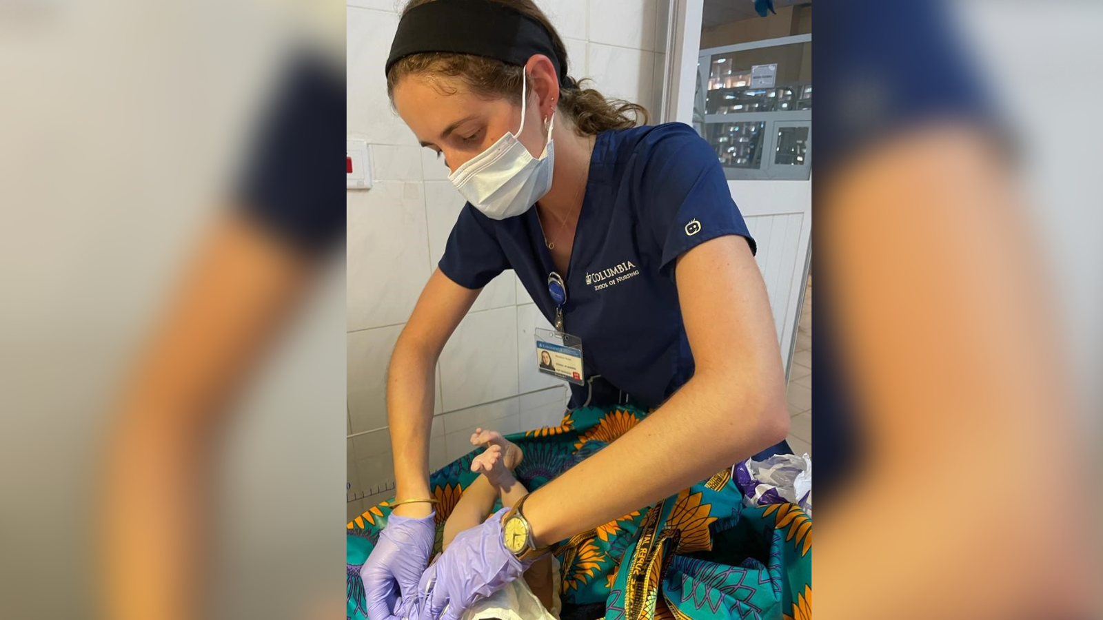 Columbia Nursing student wrapping newborn in local textiles.