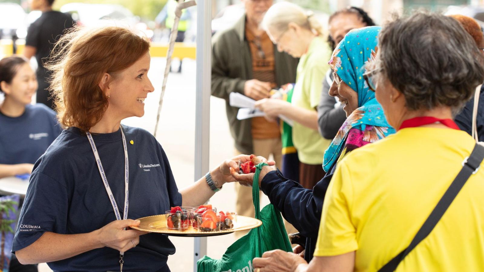 Volunteer handing out healthy snacks to members in he community