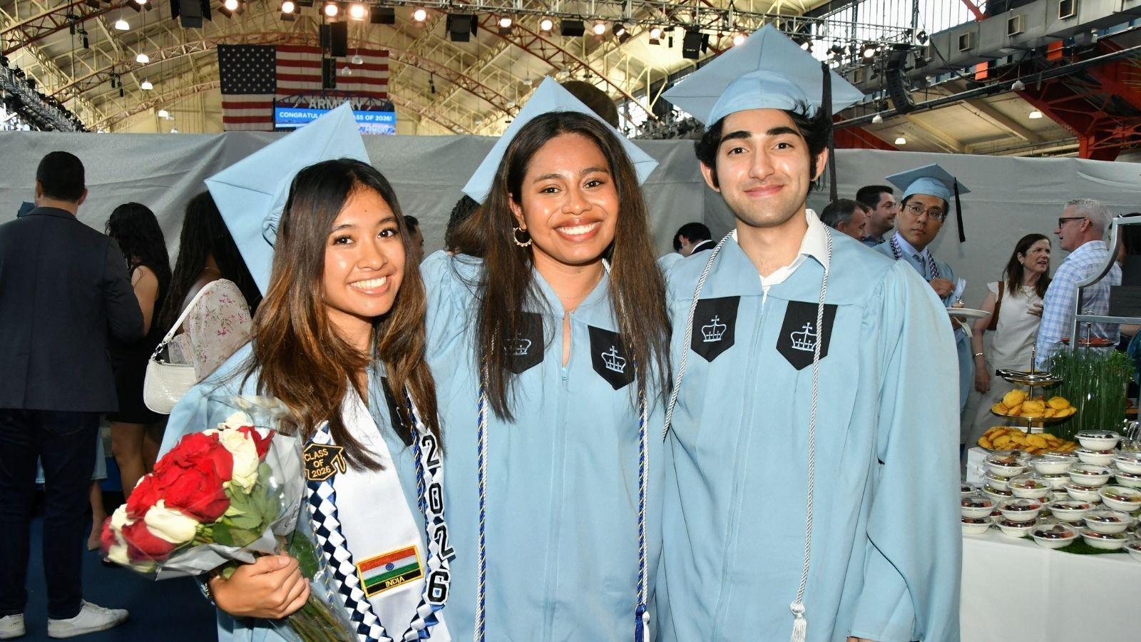 Three MDE graduates smile and pose for a photo
