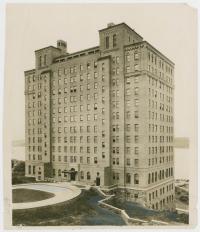 tall black & white photo of brick building with many windows