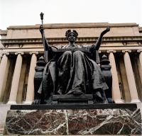 Statue raising arms in front of columned building at Columbia University.