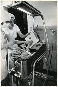 Nurse taking the foot of a newborn baby to document the imprint on a clipboard