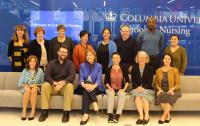 Group of board members smiling in Columbia University School of Nursing lobby.