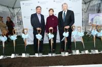 two male and one female executive posing with shovels to celebrate building groundbreaking
