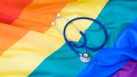 Close up of stethoscope on top of rainbow flag.