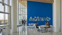 Columbia Nursing students and faculty meet in a bright, open space with floor-to-ceiling windows