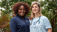 Two nursing students smiling together outside.