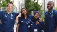Four diverse Columbia Nursing students standing together smiling.