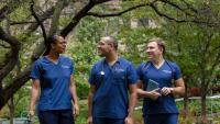 Three nursing students walking in a park.