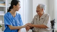 Hospice patient holding hands with nurse