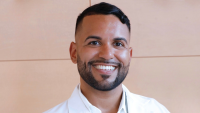 Headshot of Columbia Nursing DNP graduate, Andrew Fernandez, against a tan background