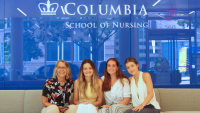 3 exchange students with faculty member, Dr. Jeanne Churchill sitting on couch in front of blue background.