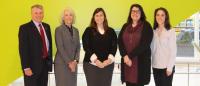 Jonas Team Photo of the Jonas Center team, consisting of five people standing and smiling at the camera, in Columbia Nursing's new building.