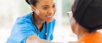 Female nurse comforting a older patient.
