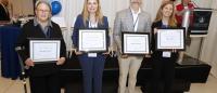 Four alumni posing with awards received at Reunion.