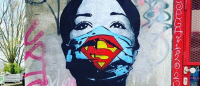 Spray paint mural of nurse wearing superman mask.