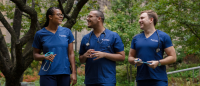Three nursing students walking outside in scrubs.