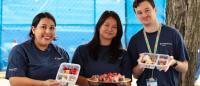 Three nursing students displaying healthy snacks for the community.