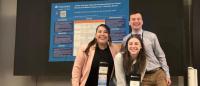 Three Columbia Nursing students posing in front of a research poster
