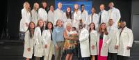 large group photo of DNP students in white coats