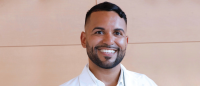 Headshot of Columbia Nursing DNP graduate, Andrew Fernandez, against a tan background